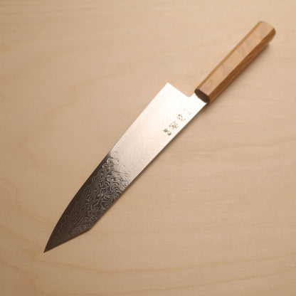 A Japanese kitchen knife with a Damascus steel blade and a light wood handle, placed diagonally on a light wood grain background.
